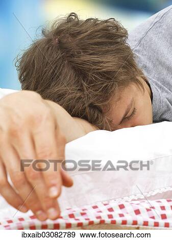 "Young man lying in bed, asleep" View Large Photo Image Stock Photo - "Young man lying in bed, asleep". Fotosearch