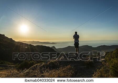 "Young man photographing the sunset, sunset by the sea, Gulf of Saint-Florent, Corsica, France, Europe" View Large Photo Image Picture - "Young man photographing the sunset, sunset by the sea, Gulf of Saint-Florent, Corsica, France, Europe". Fotosearch