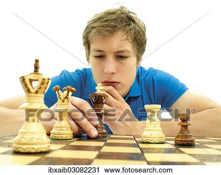 Stock Image - "Young man playing chess, concentrating". Fotosearch
