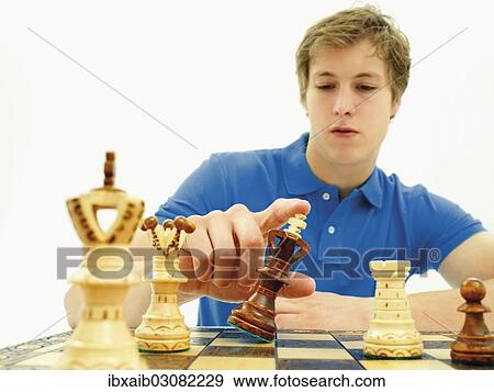 Stock Photo - "Young man playing chess, concentrating". Fotosearch