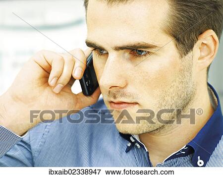 "Young man speaking on his mobile phone, serious face" View Large Photo Image Stock Photo - "Young man speaking on his mobile phone, serious face". Fotosearch