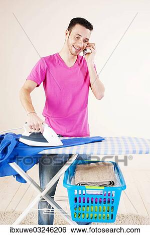 "Young man talking on the telephone while doing the ironing, Mannheim, Baden-Wurttemberg, Germany, Europe" View Large Photo Image Stock Photograph - "Young man talking on the telephone while doing the ironing, Mannheim, Baden-Wurttemberg, Germany, Europe". Fotosearch