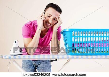 "Young man talking on the telephone while leaning on an ironing board, Mannheim, Baden-Wurttemberg, Germany, Europe" View Large Photo Image Stock Photography - "Young man talking on the telephone while leaning on an ironing board, Mannheim, Baden-Wurttemberg, Germany, Europe". Fotosearch