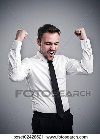 Stock Image - "Young man wearing a shirt and a tie, cheering, success, victory pose". Fotosearch