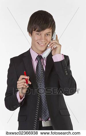 "Young man wearing a suit and tie, smiling while talking on the phone" View Large Photo Image Stock Photo - "Young man wearing a suit and tie, smiling while talking on the phone". Fotosearch