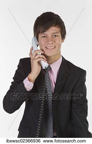 "Young man wearing a suit and tie, smiling while talking on the phone" View Large Photo Image Stock Photograph - "Young man wearing a suit and tie, smiling while talking on the phone". Fotosearch