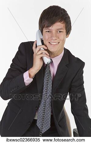 "Young man wearing a suit and tie, smiling while talking on the phone" View Large Photo Image Stock Photography - "Young man wearing a suit and tie, smiling while talking on the phone". Fotosearch