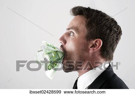 Young man wearing a suit with 100-euro notes stuffed into his mouth View Large Photo Image Stock Photo - Young man wearing a suit with 100-euro notes stuffed into his mouth. Fotosearch