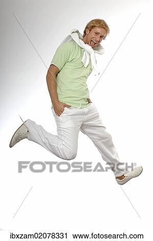 Stock Image - "Young man wearing casual summer clothes, jumping in the air for joy". Fotosearch