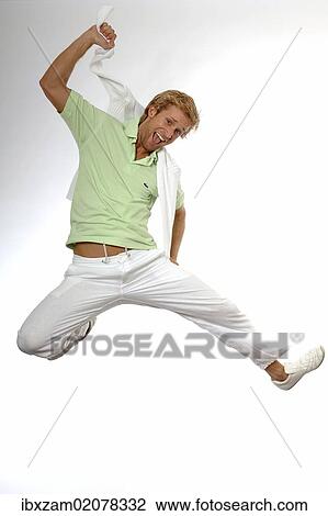Stock Image - "Young man wearing casual summer clothes, jumping in the air for joy". Fotosearch