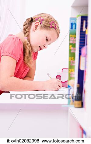 Young schoolgirl doing her homework at her desk View Large Photo Image Stock Photo - Young schoolgirl doing her homework at her desk. Fotosearch