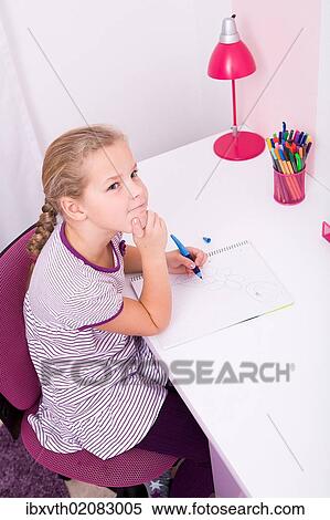 Young schoolgirl doing her homework at her desk View Large Photo Image Stock Photography - Young schoolgirl doing her homework at her desk. Fotosearch