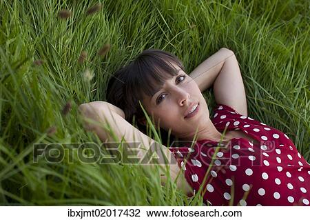 Stock Image - "Young woman, 25, lying in a meadow". Fotosearch