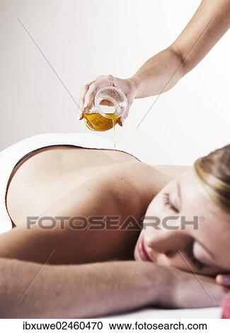 Young woman about to receive a massage with oil View Large Photo Image Stock Image - Young woman about to receive a massage with oil. Fotosearch