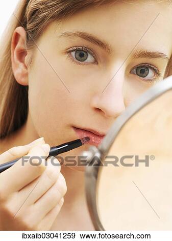 "Young woman applying make-up, lip gloss" View Large Photo Image Stock Photo - "Young woman applying make-up, lip gloss". Fotosearch