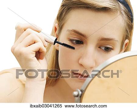 Stock Photography - "Young woman applying make-up, mascara". Fotosearch