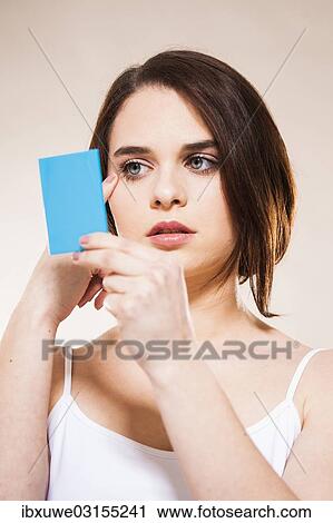 Stock Image - "Young woman applying make-up, Mannheim, Baden-Wurttemberg, Germany, Europe". Fotosearch