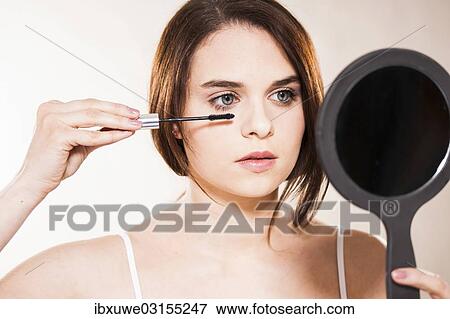 "Young woman applying make-up, Mannheim, Baden-Wurttemberg, Germany, Europe" View Large Photo Image Stock Photo - "Young woman applying make-up, Mannheim, Baden-Wurttemberg, Germany, Europe". Fotosearch