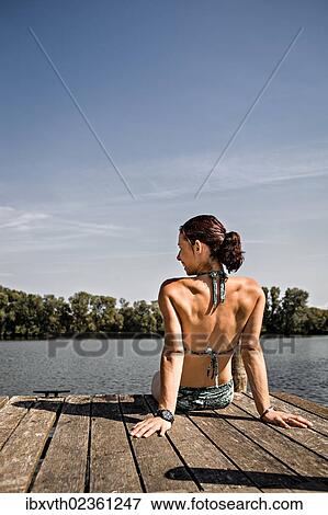 Stock Photo - Young woman at lakeside. Fotosearch