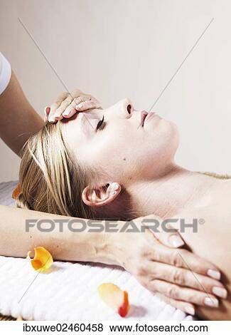 Young woman being treated by a therapist on her head and upper torso View Large Photo Image Stock Photo - Young woman being treated by a therapist on her head and upper torso. Fotosearch