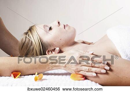 Stock Photograph - Young woman being treated by a therapist on her head and upper torso. Fotosearch