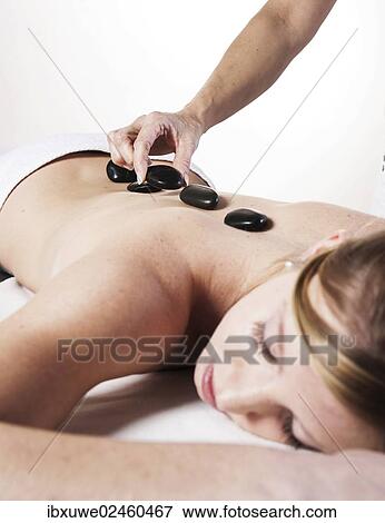 "Young woman being treated with hot stones, hot stone massage" View Large Photo Image Stock Photo - "Young woman being treated with hot stones, hot stone massage". Fotosearch