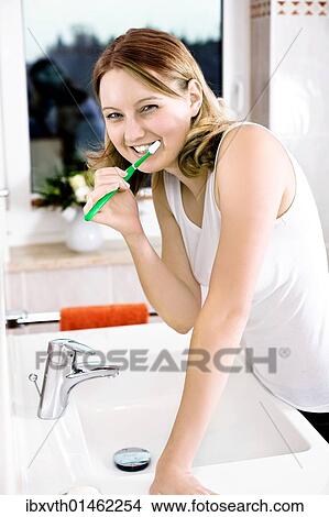 Young woman brushing her teeth View Large Photo Image Picture - Young woman brushing her teeth. Fotosearch