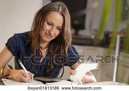 Stock Photo - Young woman controlling her finances. Fotosearch