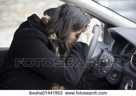Young woman despairing at the wheel View Large Photo Image Stock Image - Young woman despairing at the wheel. Fotosearch