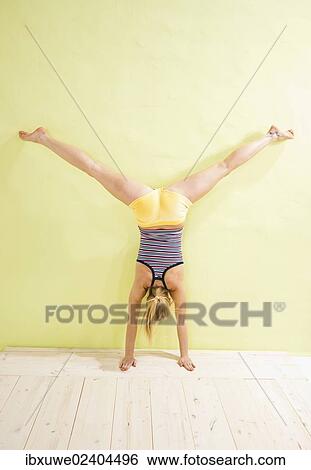 Young woman doing a handstand View Large Photo Image Stock Photograph - Young woman doing a handstand. Fotosearch