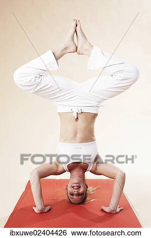 Young woman doing a headstand View Large Photo Image Stock Photograph - Young woman doing a headstand. Fotosearch