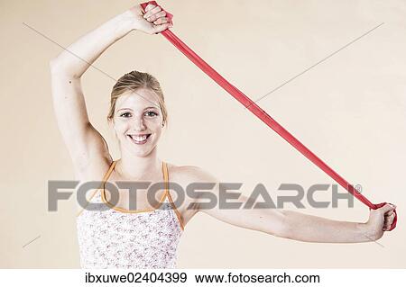 Young woman doing exercises with a Theraband View Large Photo Image Stock Photo - Young woman doing exercises with a Theraband. Fotosearch