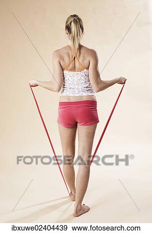 Young woman doing exercises with a Theraband View Large Photo Image Stock Photo - Young woman doing exercises with a Theraband. Fotosearch