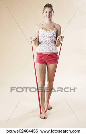 Young woman doing exercises with a Theraband View Large Photo Image Stock Photograph - Young woman doing exercises with a Theraband. Fotosearch