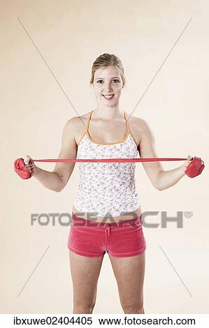 Stock Photography - Young woman doing exercises with a Theraband. Fotosearch