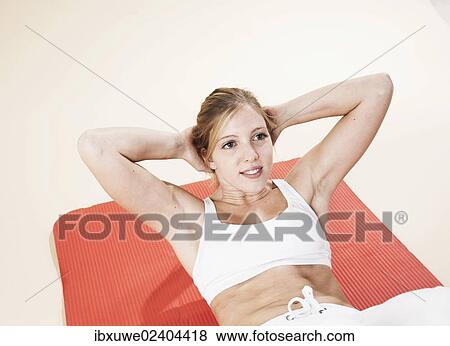 Young woman doing sit-ups View Large Photo Image Stock Photo - Young woman doing sit-ups. Fotosearch
