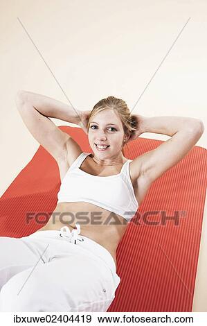 Stock Photo - Young woman doing sit-ups. Fotosearch