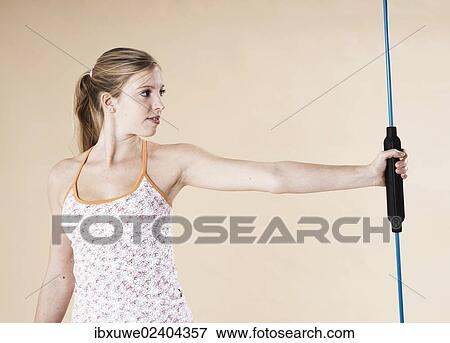 Stock Photo - Young woman doing sport exercises with a vibrating rod. Fotosearch