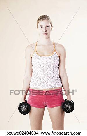 Young woman doing strength training with dumbbells View Large Photo Image Picture - Young woman doing strength training with dumbbells. Fotosearch