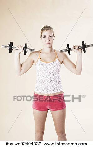 Stock Photo - Young woman doing strength training with dumbbells. Fotosearch