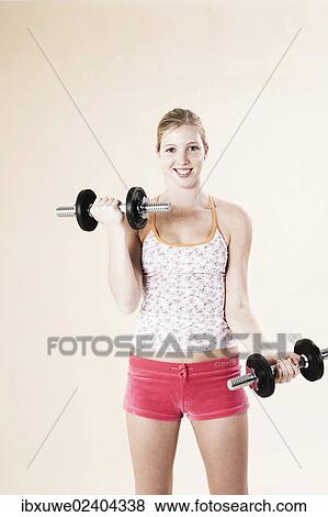 Young woman doing strength training with dumbbells View Large Photo Image Stock Photo - Young woman doing strength training with dumbbells. Fotosearch