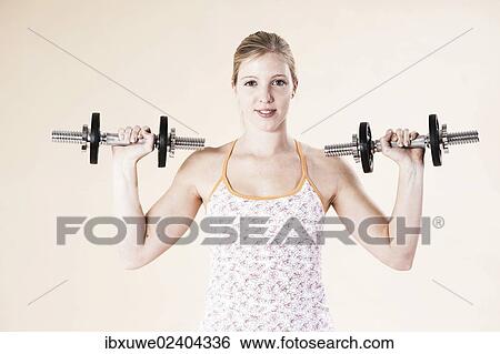 Young woman doing strength training with dumbbells View Large Photo Image Stock Photograph - Young woman doing strength training with dumbbells. Fotosearch
