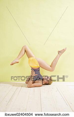 Young woman doing stretching and strengthening exercises View Large Photo Image Picture - Young woman doing stretching and strengthening exercises. Fotosearch