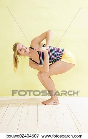 Young woman doing stretching and strengthening exercises View Large Photo Image Stock Photo - Young woman doing stretching and strengthening exercises. Fotosearch