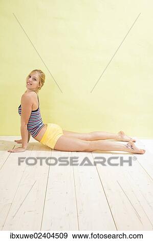 Young woman doing stretching and strengthening exercises View Large Photo Image Stock Photo - Young woman doing stretching and strengthening exercises. Fotosearch