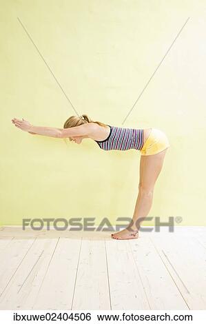 Stock Photograph - Young woman doing stretching and strengthening exercises. Fotosearch
