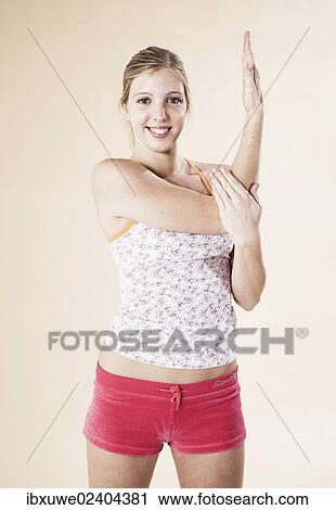 Young woman doing stretching exercises View Large Photo Image Stock Image - Young woman doing stretching exercises. Fotosearch
