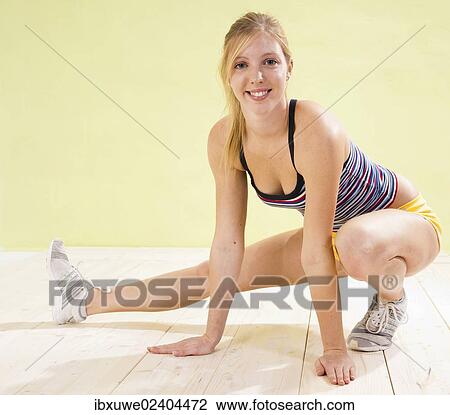 Stock Image - Young woman doing stretching exercises. Fotosearch