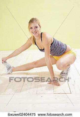 Young woman doing stretching exercises View Large Photo Image Stock Photography - Young woman doing stretching exercises. Fotosearch