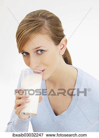 Young woman drinking from a glass of milk View Large Photo Image Stock Photo - Young woman drinking from a glass of milk. Fotosearch